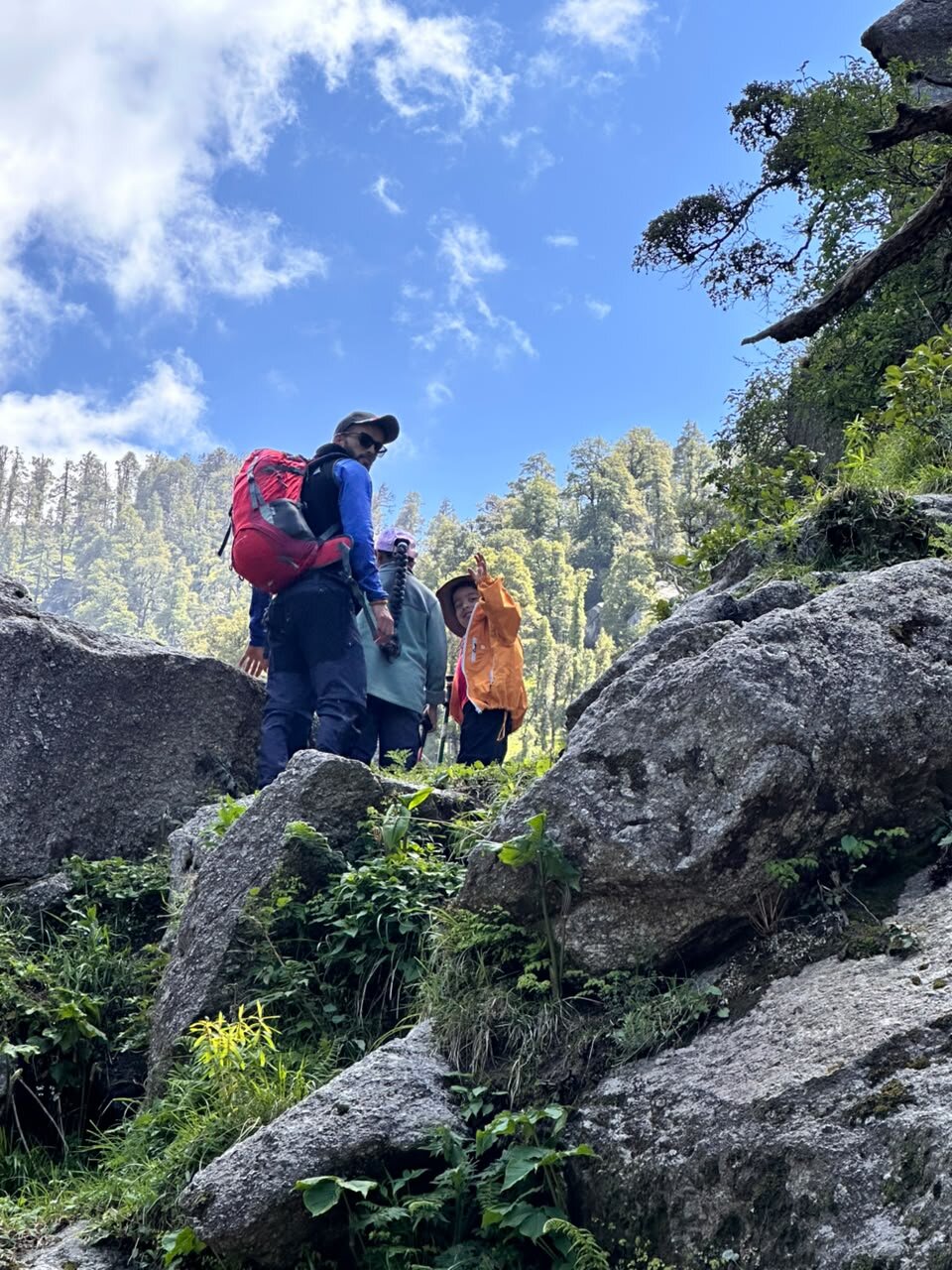 Yuvan, Zayra and the trek guide climbing over big boulders on the trail