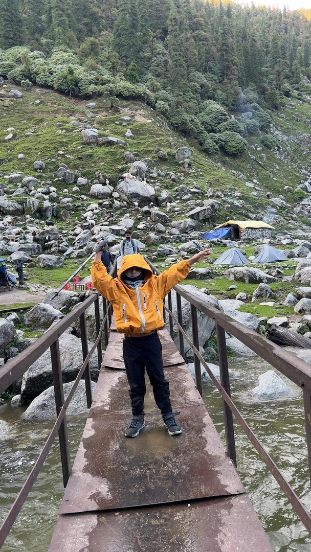 Yuvan crossing a metal bridge near the campsite
