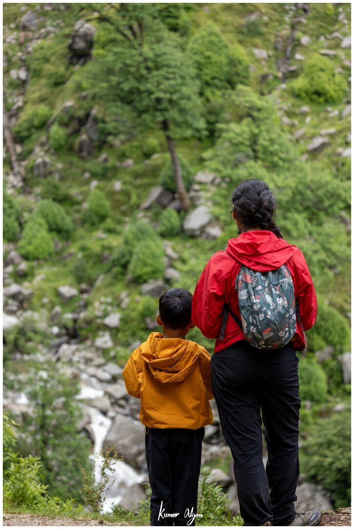 Yuvan and Ma looking towards a waterfall in the valley