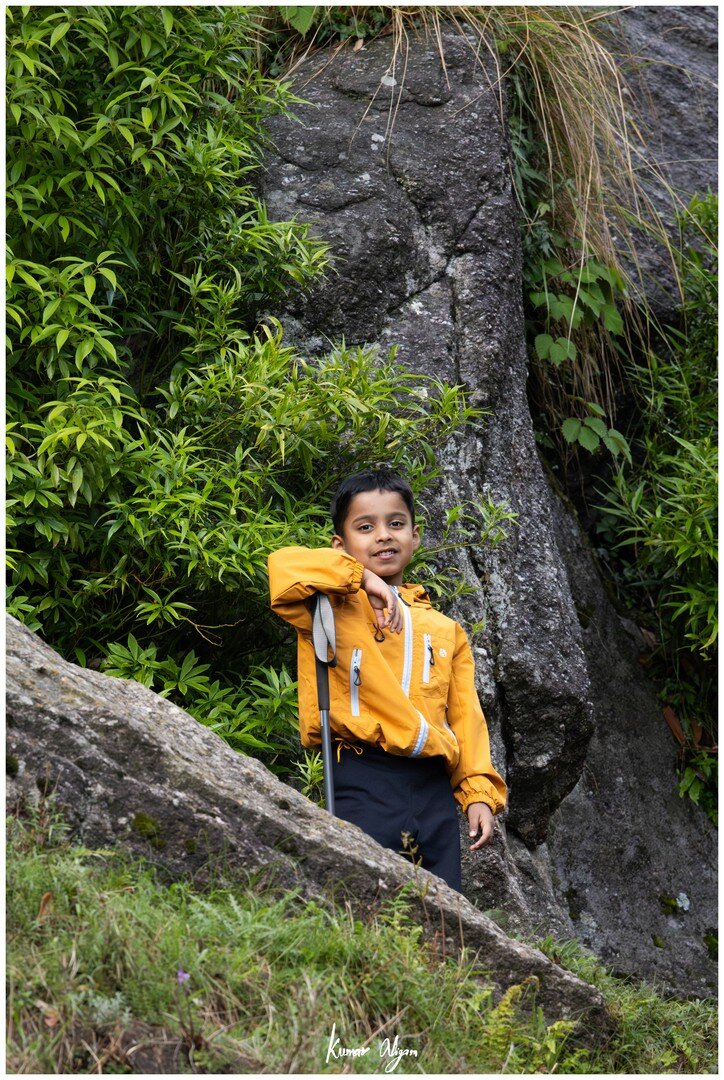 Yuvan resting against a big boulder