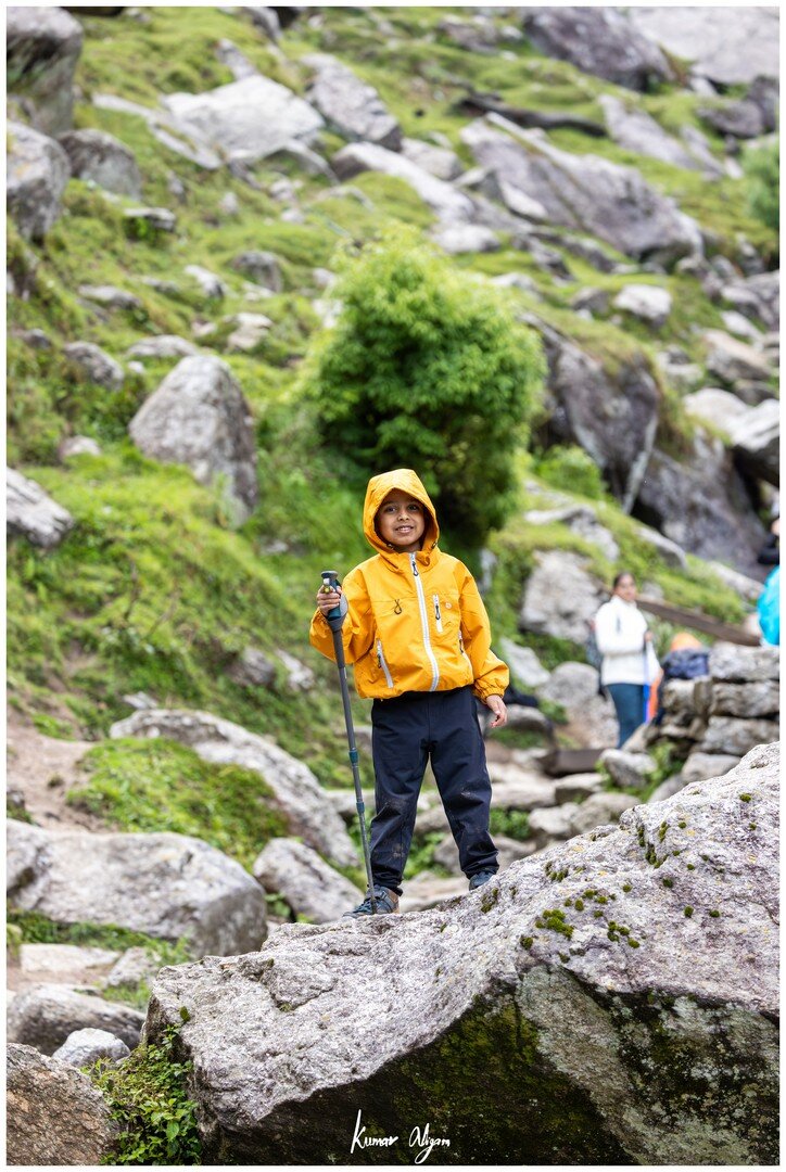 Yuvan standing on a boulder with his trekking pole
