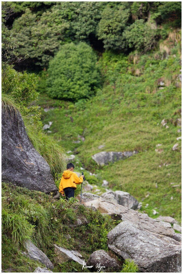 Yuvan walking along a grassy mountain slope