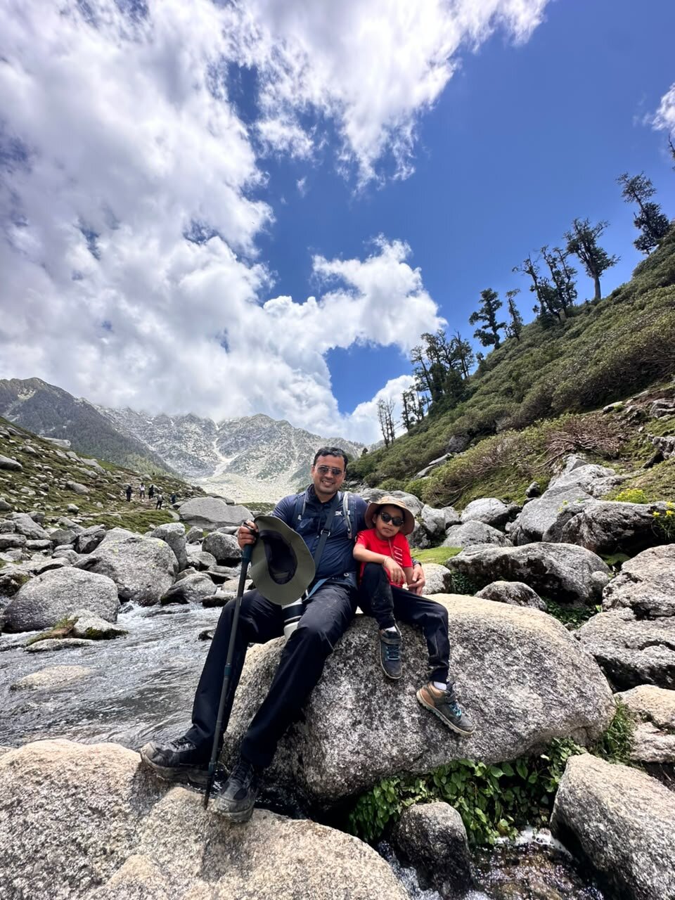 Yuvan and Papa sitting on a boulder beside the glacier-fed stream where they slipped