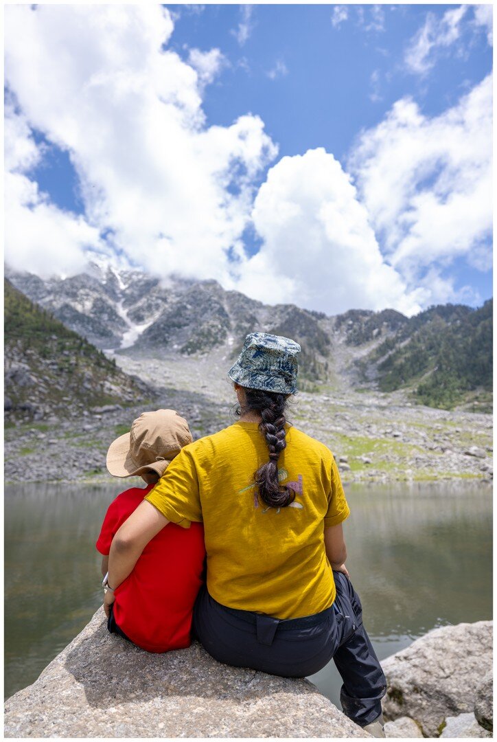 Yuvan and Ma sitting together looking out at the lake and mountains