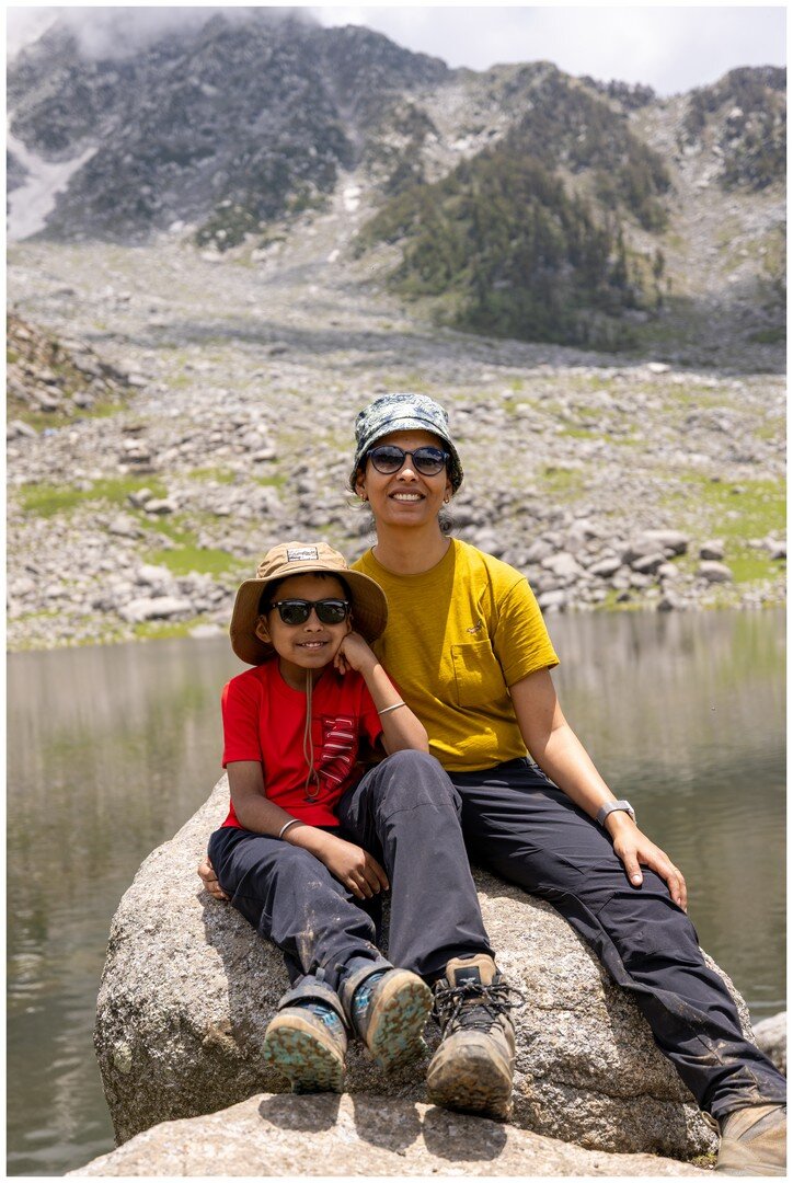Yuvan sitting with Ma on a rock beside the lake