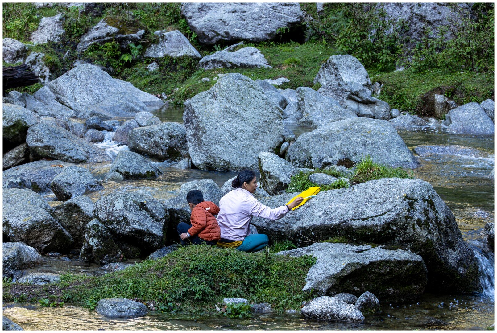 Yuvan and Ma resting by the stream on the way to the lake