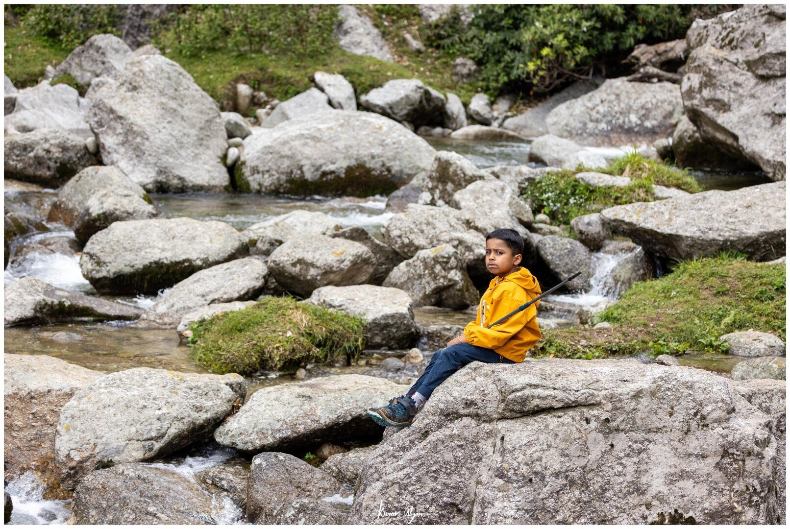 Yuvan sitting quietly on a boulder by the mountain stream on the last morning